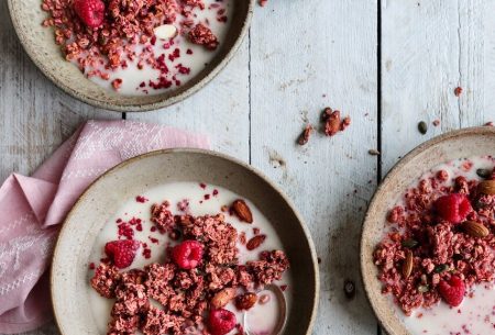 3 bowls of raspberry granola, milk and fresh raspberries