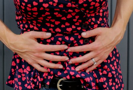 View Is constipation really what we think it is? A female stomach with two hands placed on the stomach