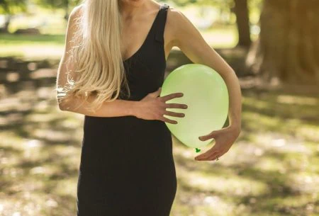 Megan Rossi outside in nature with a green balloon