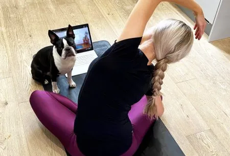 Megan Rossi on a yoga mat with laptop and dog