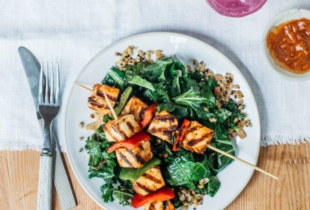 View Eating purely plant-based? Here are the key nutrients to consider A plate with quinoa, kale and veggie skewers on a wooden table with a white linen cloth and knife and fork, pink drink with ice and red dip