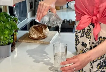 A woman pouring a glass of water