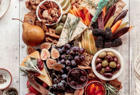 Cheese platter with fruit, veggies, nuts and olives