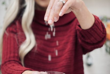 View Salt & the gut Megan Rossi with a small bowl of salt in one hand and spinkling it in the other hand