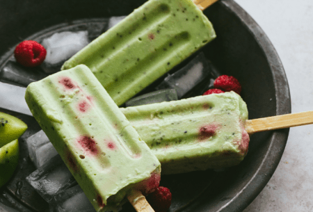 Three green fruity fibre-filled ice lollies on sticks