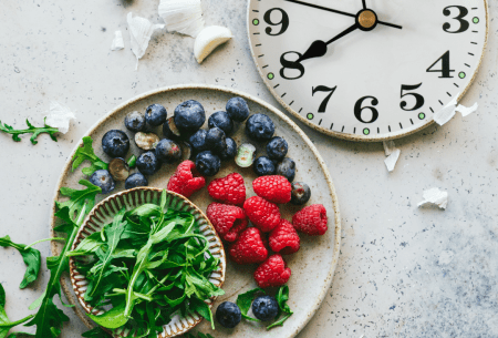 View OMAD & 20:4 intermittent fasting: 6 things you need to know A plate of raspberries, blueberries and rocket alongside a traditional clock face showing the time of 8 o'clock