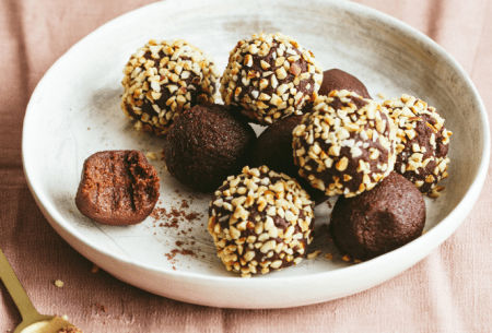 Bowl of eight chocolate truffles, half coated in finely chopped hazelnuts