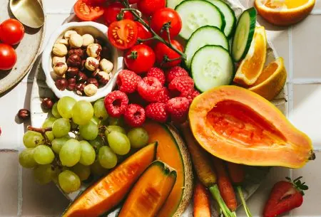 A large plate filled with mixed fruits, vegetables and nuts