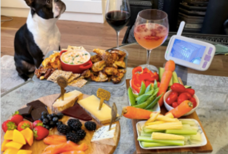 Table in home environment covered with snacking platters to diversify your diet, with drink and dog in background