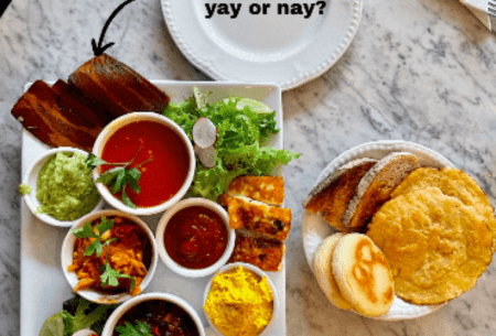 View Mock meat, is it really a better option? Platter of snacking foods set on a kitchen bench, including some mock meat with a title reading 'mock meat, yay or nay?'