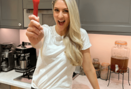Dr Megan Rossi at home holding up a red chilli towards camera and smiling