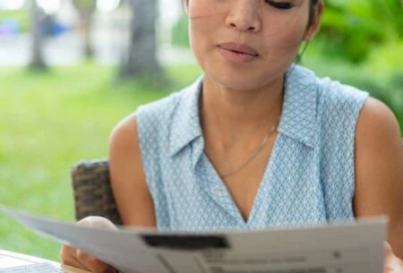 IBS management: photo of woman outdoors reading a menu to reflect challenges of eating out with IBS