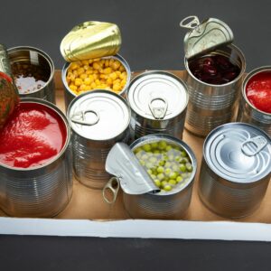 Photo of a shelf including 9 tins of food, including canned tomatoes, sweetcorn and peas. Some of the cans are open and some are closed. To demonstrate diet myth of processed foods