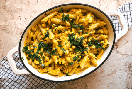 Photo of a casserole dish on a kitchen work surface with the dish sunshine pasta which includes herbs sprinkled on top