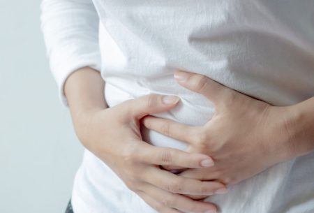 An image of a woman holding her stomach