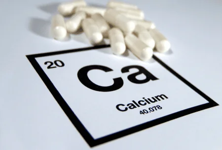 An image of the calcium symbol with calcium supplements next to it.