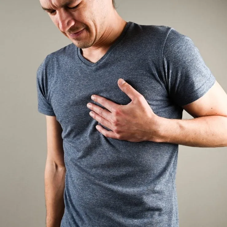 An image of a man uncomfortably clutching his chest