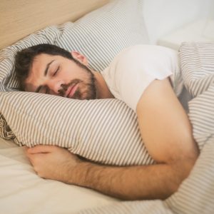 A man hugging the pillow while sleeping