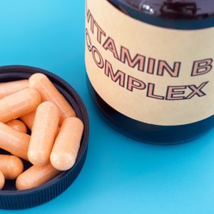 A photo of vitamin b pills in a bowl next to their jar which reads 'vitamin b complex'