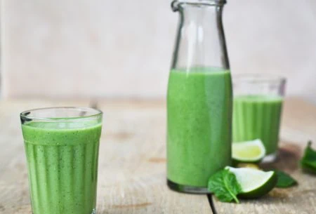 A photo of the green cooler drink with the bottle in the background