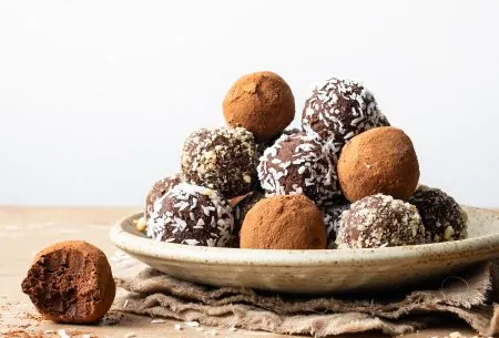 View Prebiotic-rich chocolate truffles A photo of the truffles assembled on a plate, coated in dessicated coconut and cocoa powder