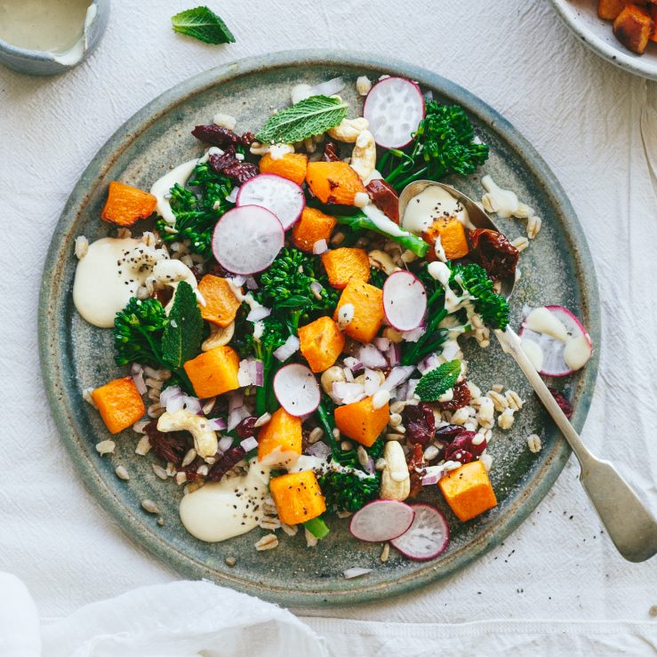 A grey plate with a summer barley and butter nut squash salad