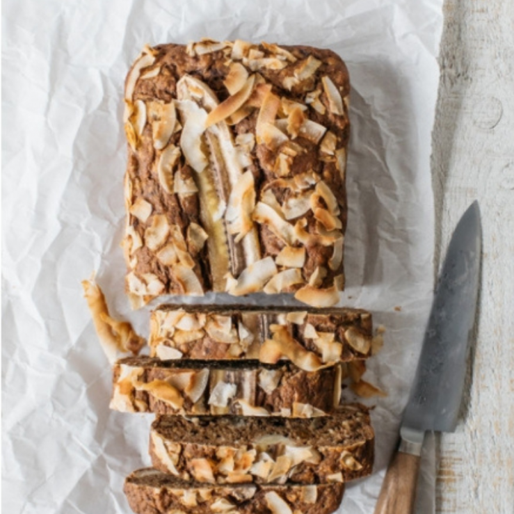 Banana fig and courgette loaf cut into slices with a knife beside it