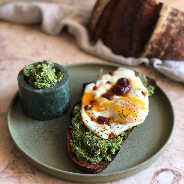 Pot of walnut and brussels sprout pesto with fried egg on sourdough toast