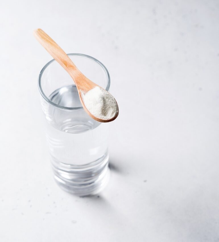 Photo of a water drink with a spoon of powder balanced on top to show how to manage a tummy bug on holiday