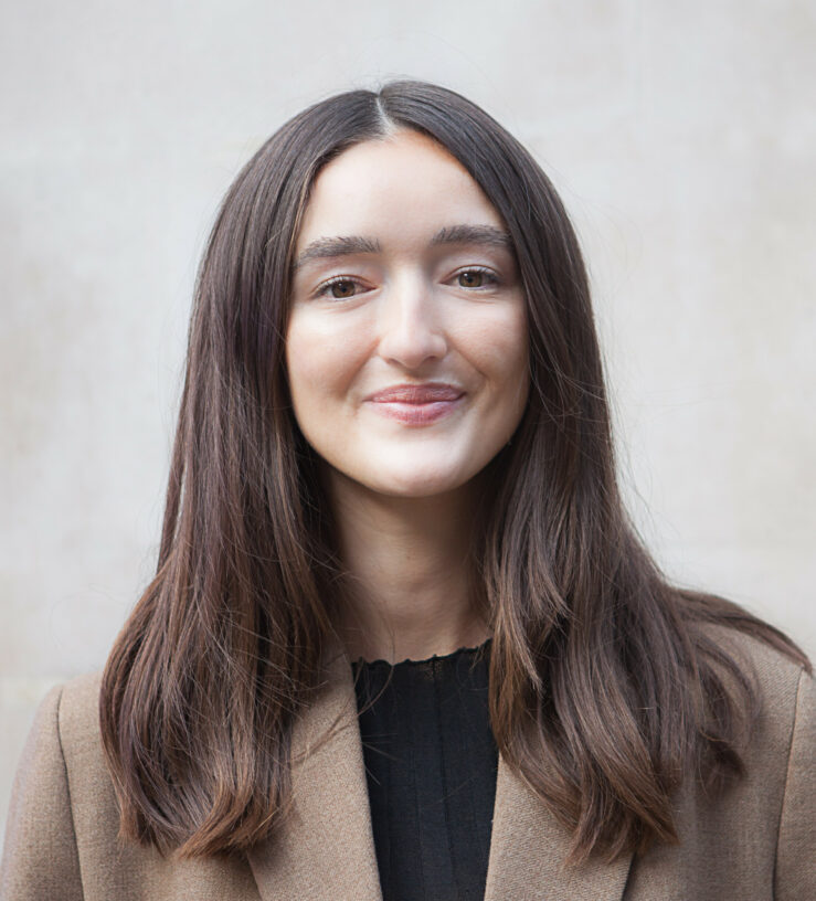 Image of Josie smiling, a brunette woman wearing a brown blazer