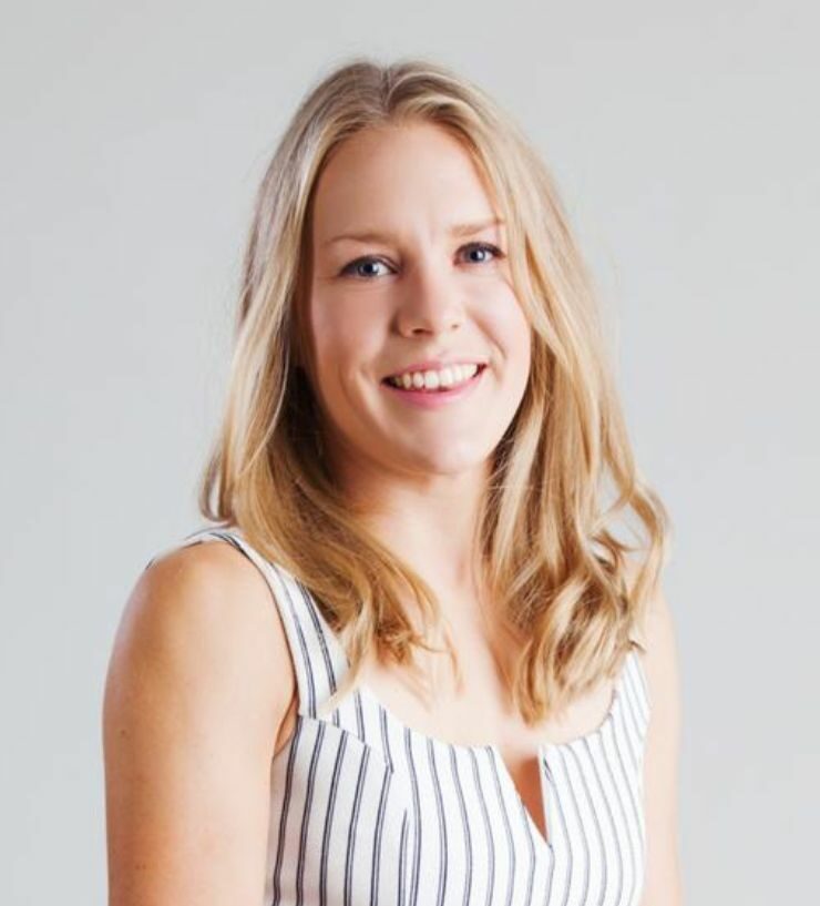 A photo of Emily smiling, a blonde woman wearing a stripy top