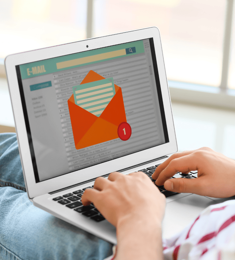 Photo of someone with laptop on their lap and imagine of a generic email inbox on screen