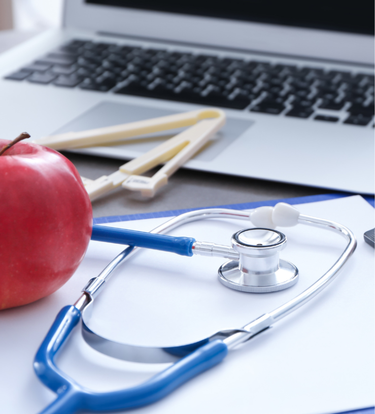 Photo of a laptop screen with a stethoscope, apple and other dietetic tools in front