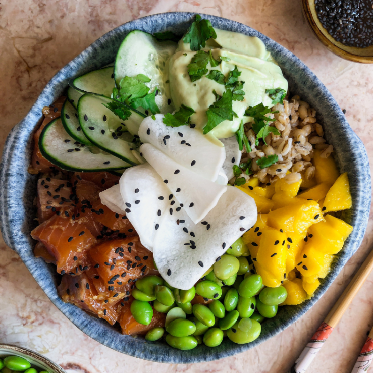 Photo of a poke bowl in a ceramic bowl with super six ingredients including edamame beans, mango and salmon