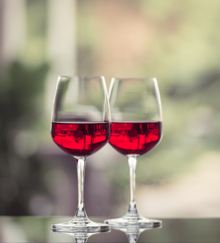 Two glasses of red wine on a table to demonstrate histamines in alcohol intolerance