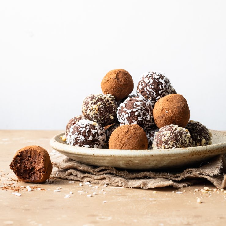 A photo of the truffles assembled on a plate, coated in dessicated coconut and cocoa powder