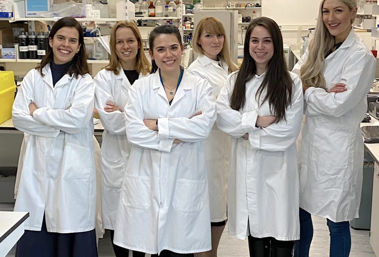 Dr Megan Rossi in a lab looking through a microscope